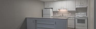 A kitchen with white appliances and cabinets.