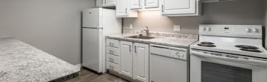 A kitchen with white appliances and cabinets.