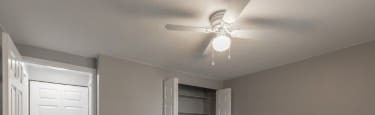 A room with a ceiling fan and a door.