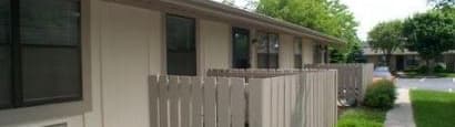 A white picket fence in front of a building.