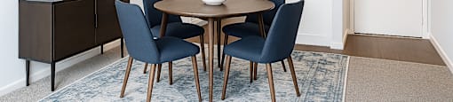 A dining room with a round table and chairs.