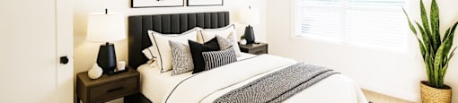 A bedroom with a large bed and a painting above it.