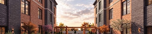 A sunset view of a brick building with a walkway in front.