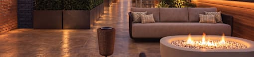 A modern outdoor patio with a fire pit and seating area.