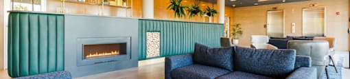 the seating area of a restaurant with blue chairs and green booths