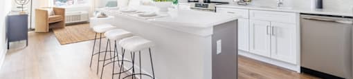 a kitchen with a large island and white cabinets