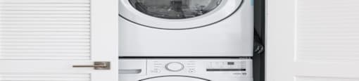 a white washer and dryer in a white closet