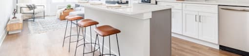 a kitchen with a large island with three stools