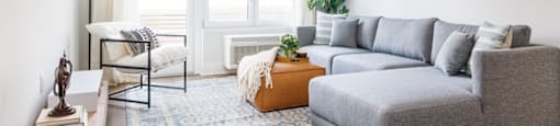a living room with a gray couch and a large window