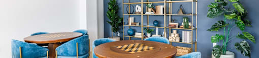 a dining room with blue chairs and a table with a chess board