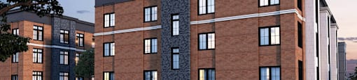 A modern building with a brick facade and a balcony with a railing.