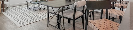 A dining room with a table surrounded by chairs and a mirror on the wall.