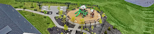 A playground with a slide and a green lawn.