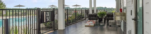 A patio with a pool in the background.