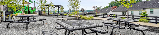 A gravel area with picnic tables and benches.