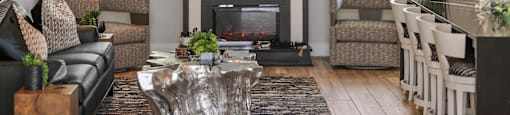 A modern living room with a fireplace and a large tree branch decoration on the wall.