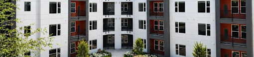 A modern apartment complex with a pool in the courtyard.