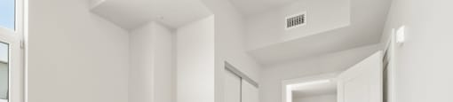 a living room with white walls and a door to a bathroom