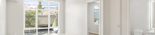 a large white kitchen with a large window and white cabinets
