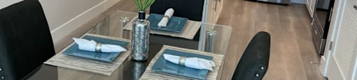 a kitchen and dining room with a glass table and chairs