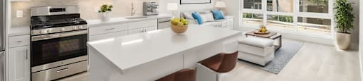 an open kitchen and living room with white cabinets and stainless steel appliances