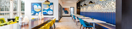 a long dining room with tables and chairs and a long bar with yellow and blue
