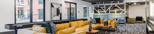 a living room with yellow couches and chairs and a table