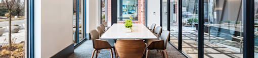 a dining room with a table and chairs in front of glass doors