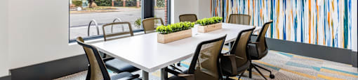 a conference room with a white table and chairs and a large window