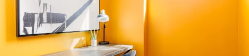 a home office with orange walls and a desk with a chair