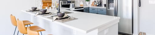 a kitchen with a large island and a stainless steel refrigerator