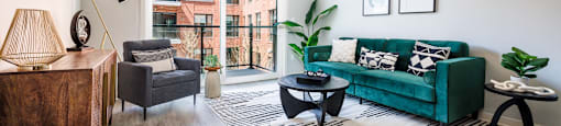 a living room with a green couch and a large window