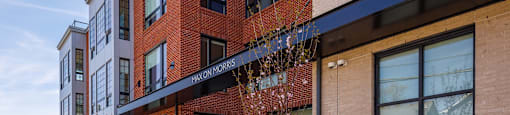 a brick building with a sidewalk and benches in front of it