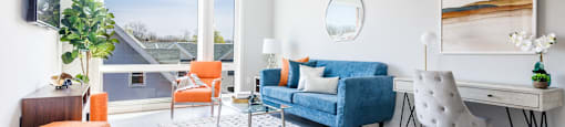 a living room with a blue couch and a table with chairs