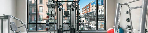 A gym with a view of the city outside the window.
