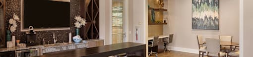 Bar area with flat-screen TV, coffee maker, mini fridge and seating; adjacent to resident lounge with desks, tables and chairs