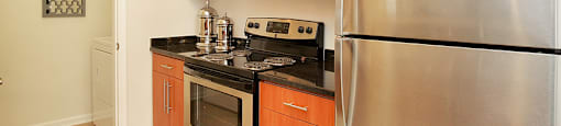 Kitchen with stainless steel appliances; door to laundry area