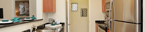 Kitchen with stainless steel appliances; open to living room; door to laundry room