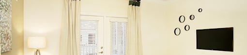 Living room with ceiling fan and door to patio