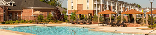 Resort-style saltwater pool surrounded by chairs and cabanas