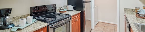 A kitchen with brown cabinets and black appliances.