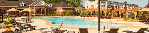 Pool surrounded by chairs and cabanas; hammock park