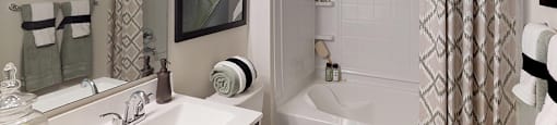 Bathroom with dark cabinets, sink and garden-style bathtub