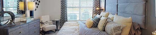 Bedroom with ceiling fan; window; door to in-room bathroom