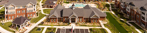 Aerial view of community clubhouse, parking lot and apartment buildings