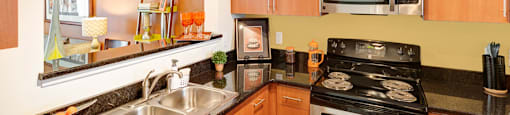Kitchen with black granite countertops; opening to living room