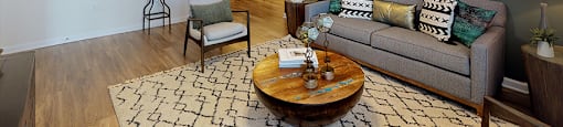 Living room with sofa and chair; ceiling fan; open to kitchen