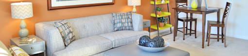 Living Room with couch; dining table with two chairs; opening to kitchen
