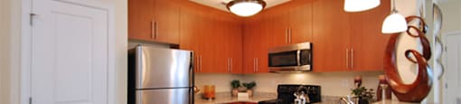 Kitchen with granite countertops; stainless steel appliances; open to living area
