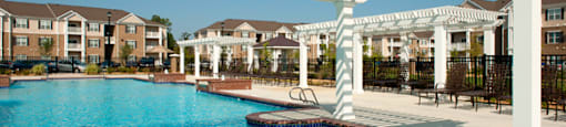 Resort-style pool with pergolas, fountains and chairs